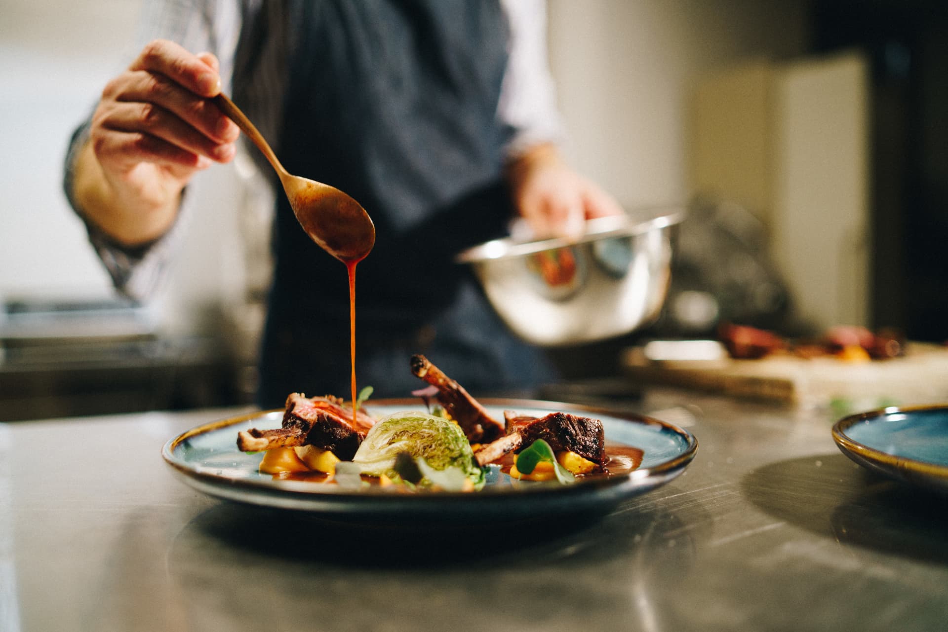Chef terminando un plato con la salsa durante el servicio